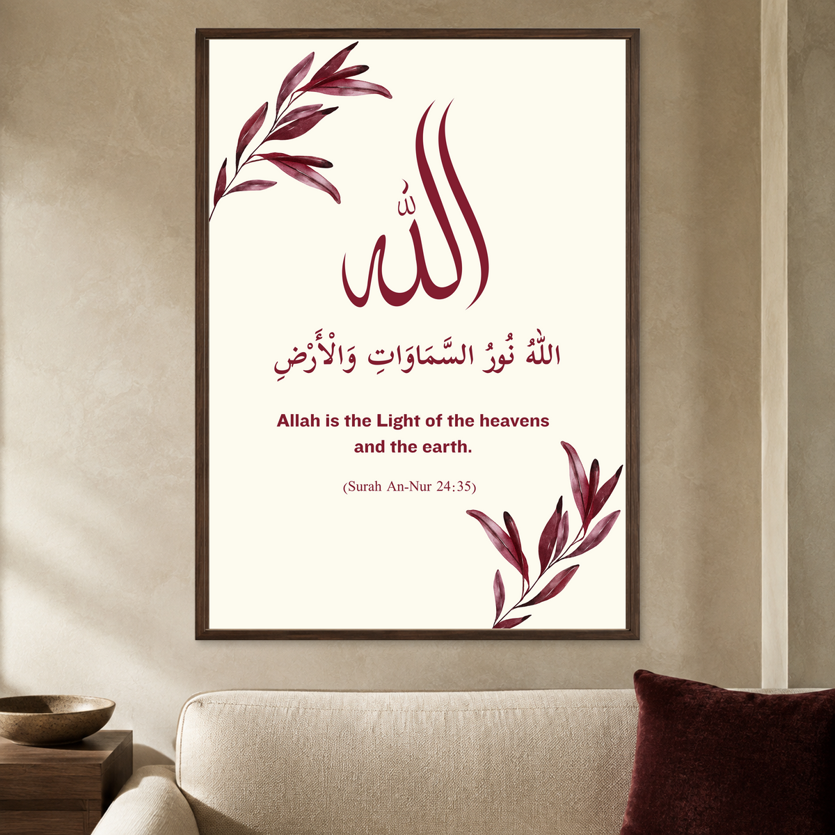 Cream wall poster with burgundy Allah calligraphy, leafy corners and An-Nur verse reference in a dark brown frame, styled in a living room